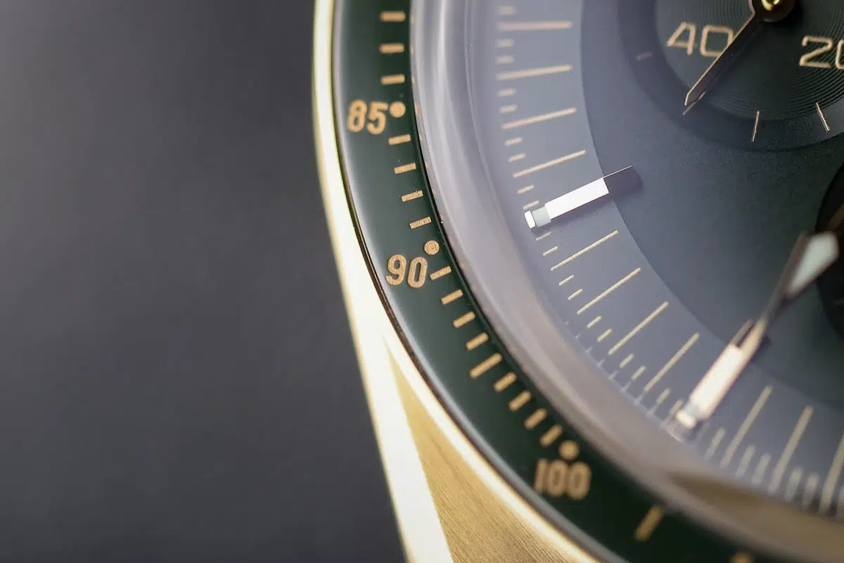 Detail of green dial and gold indices on Omega Speedmaster Moonwatch 18K Yellow Gold