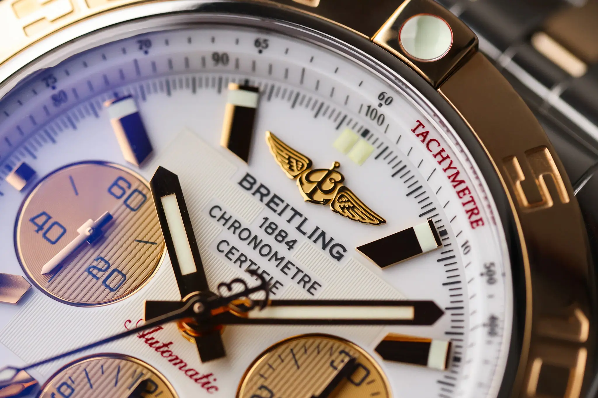 Close-up of Breitling Chronomat white dial showing chronograph subdials and applied rose gold markers