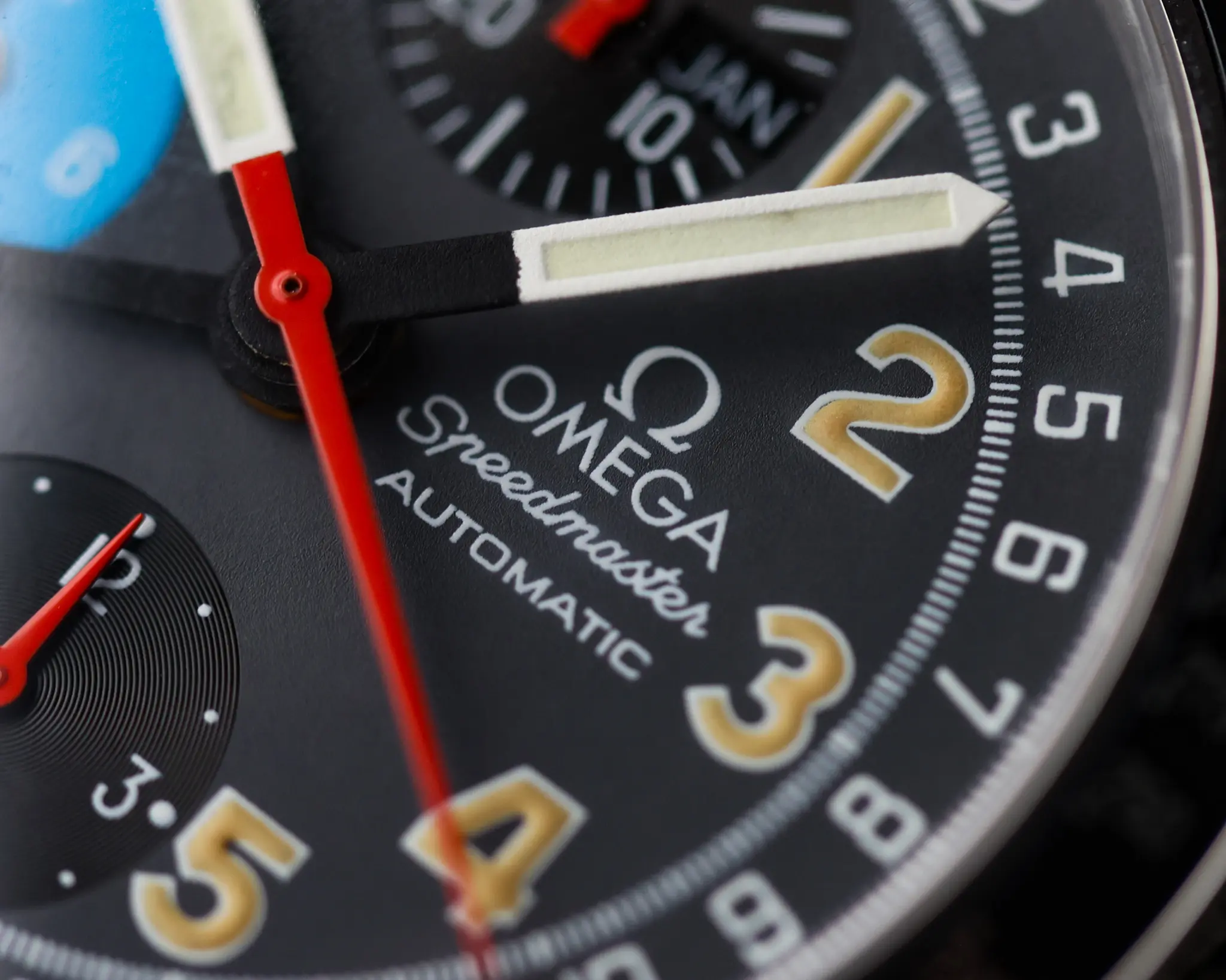 Close-up of the Omega Speedmaster Day Date dial showing Arabic numerals and chronograph details