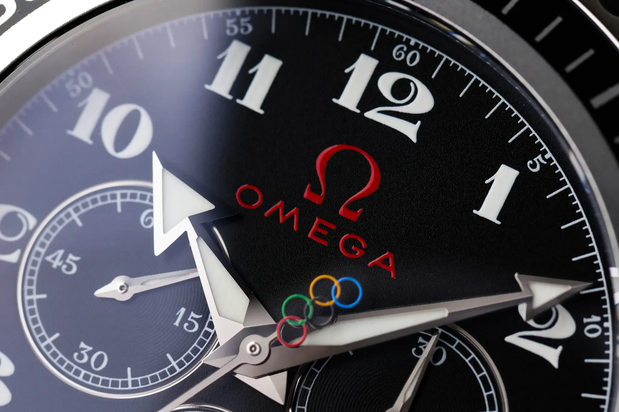 Omega Olympic Seamaster dial detail showing Olympic rings and red Omega logo at 12 o’clock