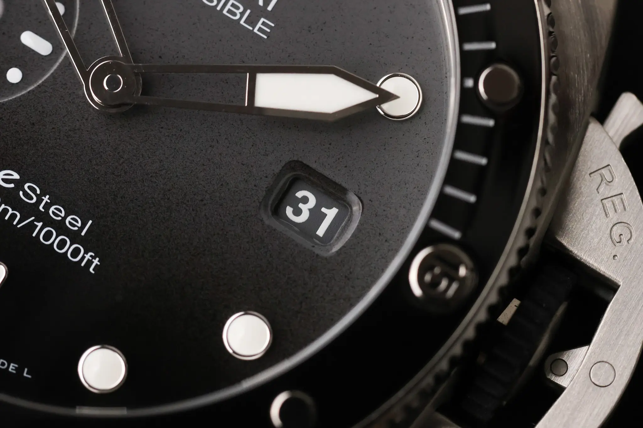 Macro detail of Panerai Submersible QuarantaQuattro Grigio Roccia dial with date window, bezel edge, and luminous hand