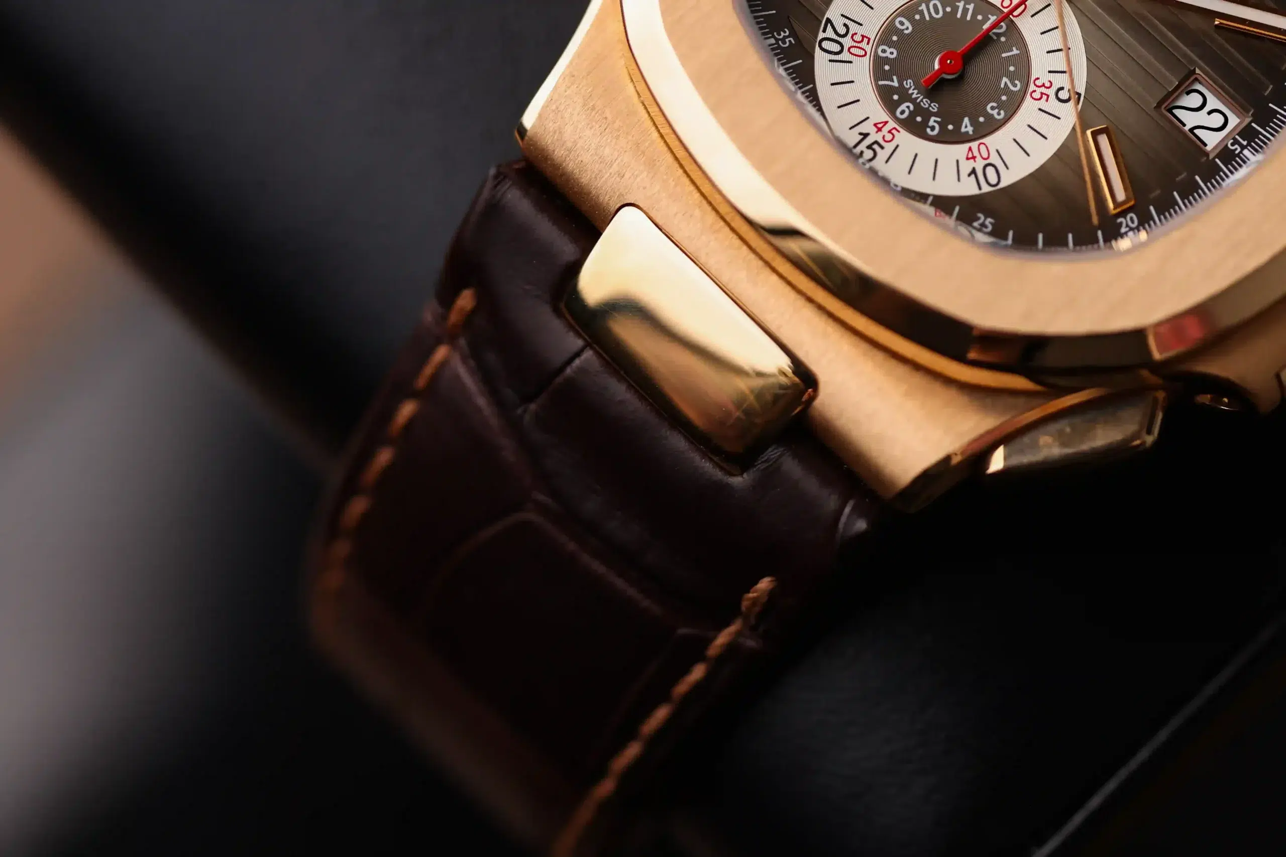 Angled wrist-side view of the Patek Philippe Nautilus Chronograph 5980R-001 showing the brown leather strap and rose-gold case