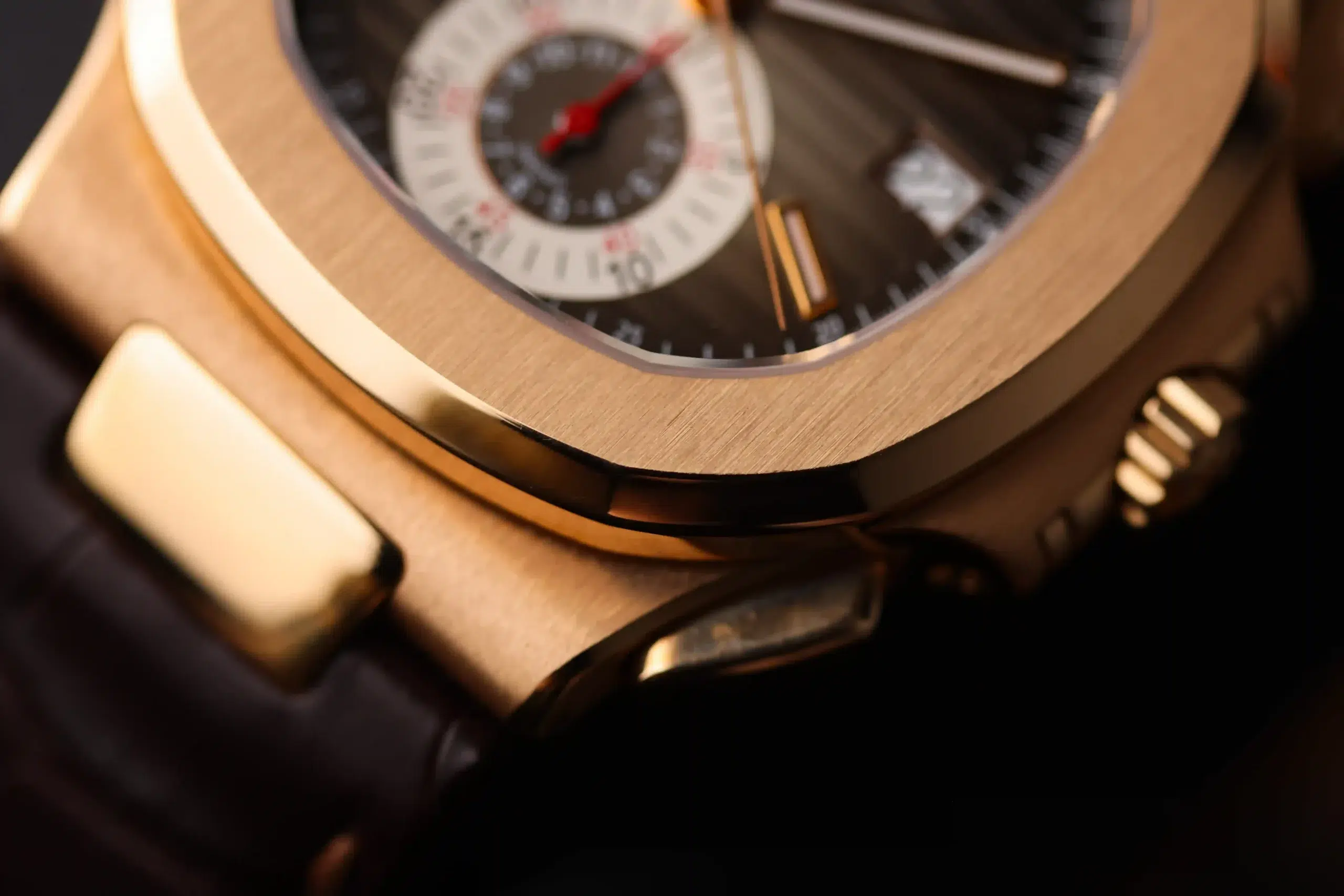 Close-up side angle of the Patek Philippe Nautilus 5980R-001 showing the rose-gold case and brown leather strap