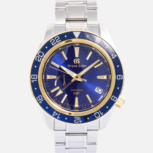 Front view of a pre-owned Grand Seiko Sport Collection Spring Drive GMT 44mm (Ref. SBGE248) in stainless steel, highlighting its 18k yellow gold rotating bezel with a blue sapphire crystal insert, deep blue sunray dial with gold-plated accents, and a stainless steel bracelet.