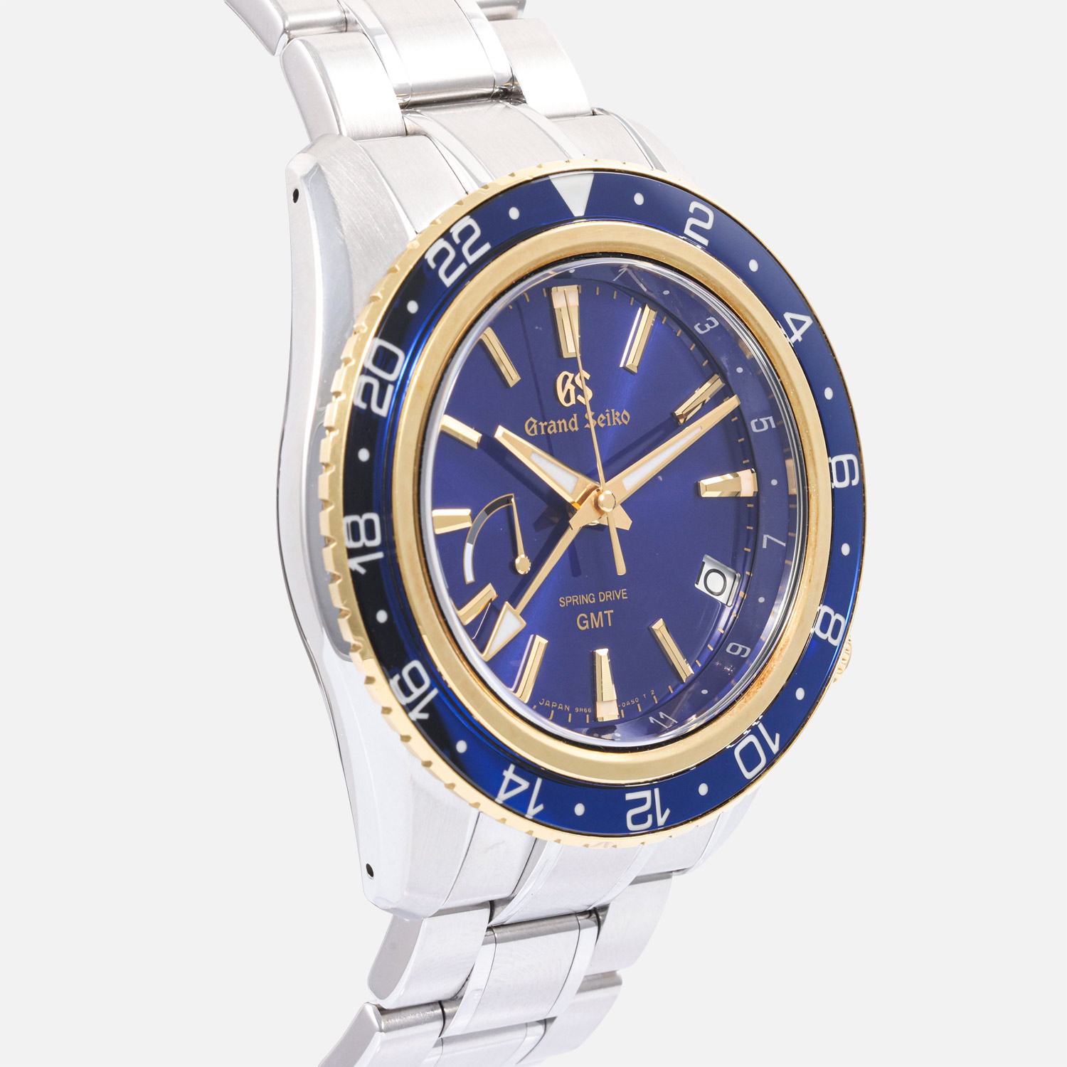 side view of a pre-owned Grand Seiko Sport Collection Spring Drive GMT 44mm (Ref. SBGE248) in stainless steel, highlighting its 18k yellow gold rotating bezel with a blue sapphire crystal insert, deep blue sunray dial with gold-plated accents, and a stainless steel bracelet.