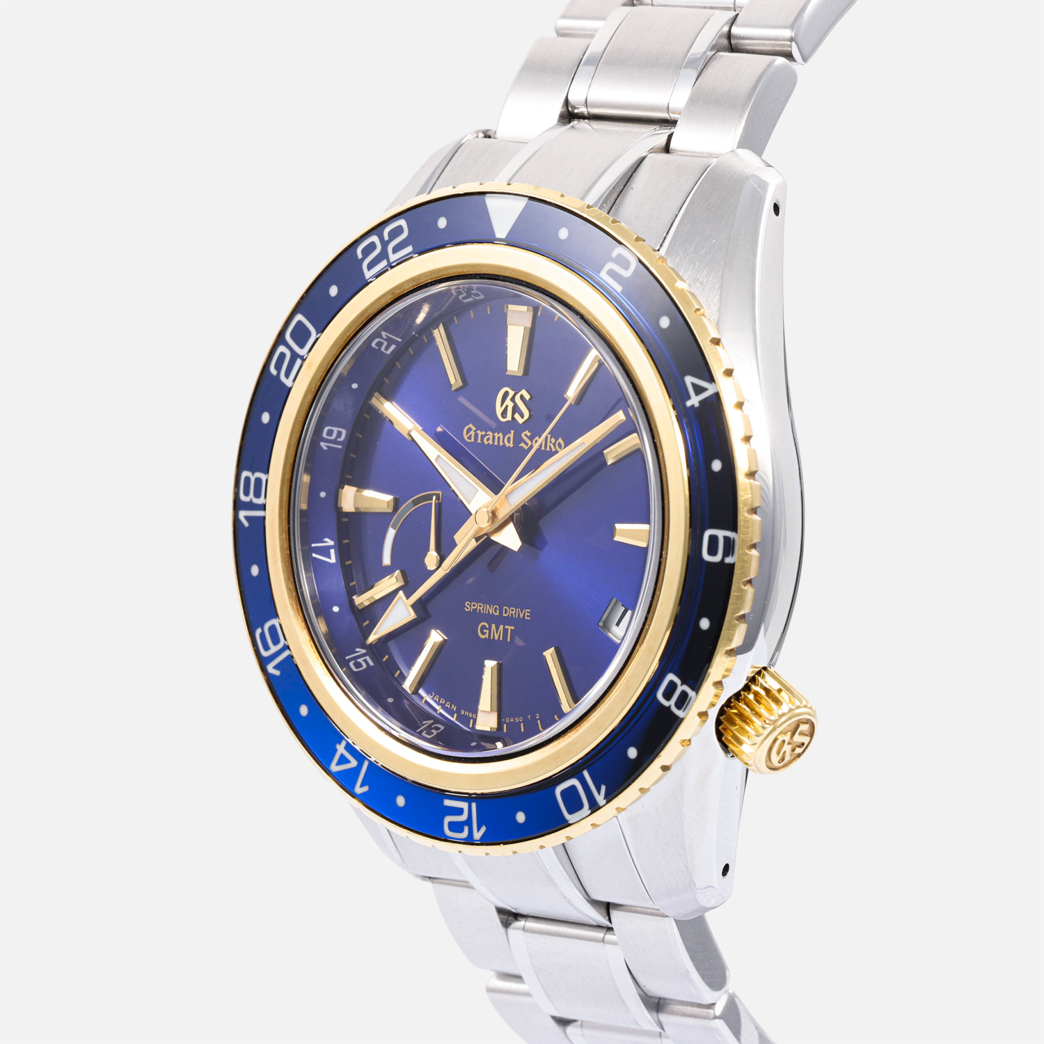 crown view of a pre-owned Grand Seiko Sport Collection Spring Drive GMT 44mm (Ref. SBGE248) in stainless steel, highlighting its 18k yellow gold rotating bezel with a blue sapphire crystal insert, deep blue sunray dial with gold-plated accents, and a stainless steel bracelet.