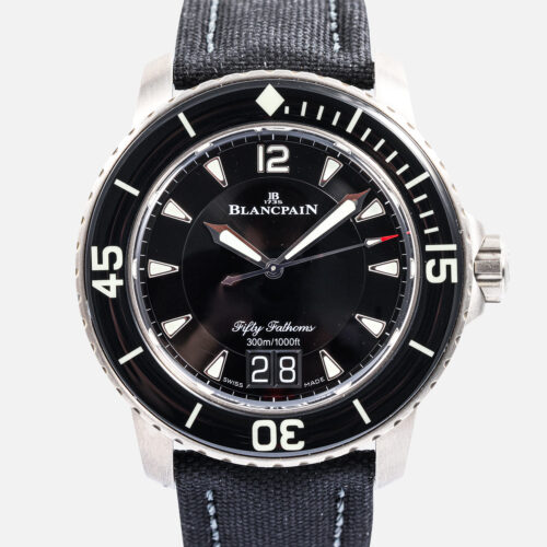 Front view of a pre-owned Blancpain Fifty Fathoms Grande Date 45mm (Ref. 5050-12B30-B52A) in satin-brushed titanium, displaying its black dial, instantaneous big date display at 6 o'clock, black sapphire unidirectional bezel, and black sailcloth strap.