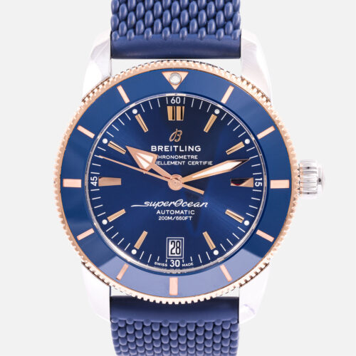 Front view of a pre-owned Breitling Superocean Heritage B20 Automatic 42mm (Ref. UB2010161C1S1) in stainless steel and 18k red gold, featuring its blue dial, blue ceramic bezel, gold-accented hands and indices, and blue mesh-pattern rubber strap.