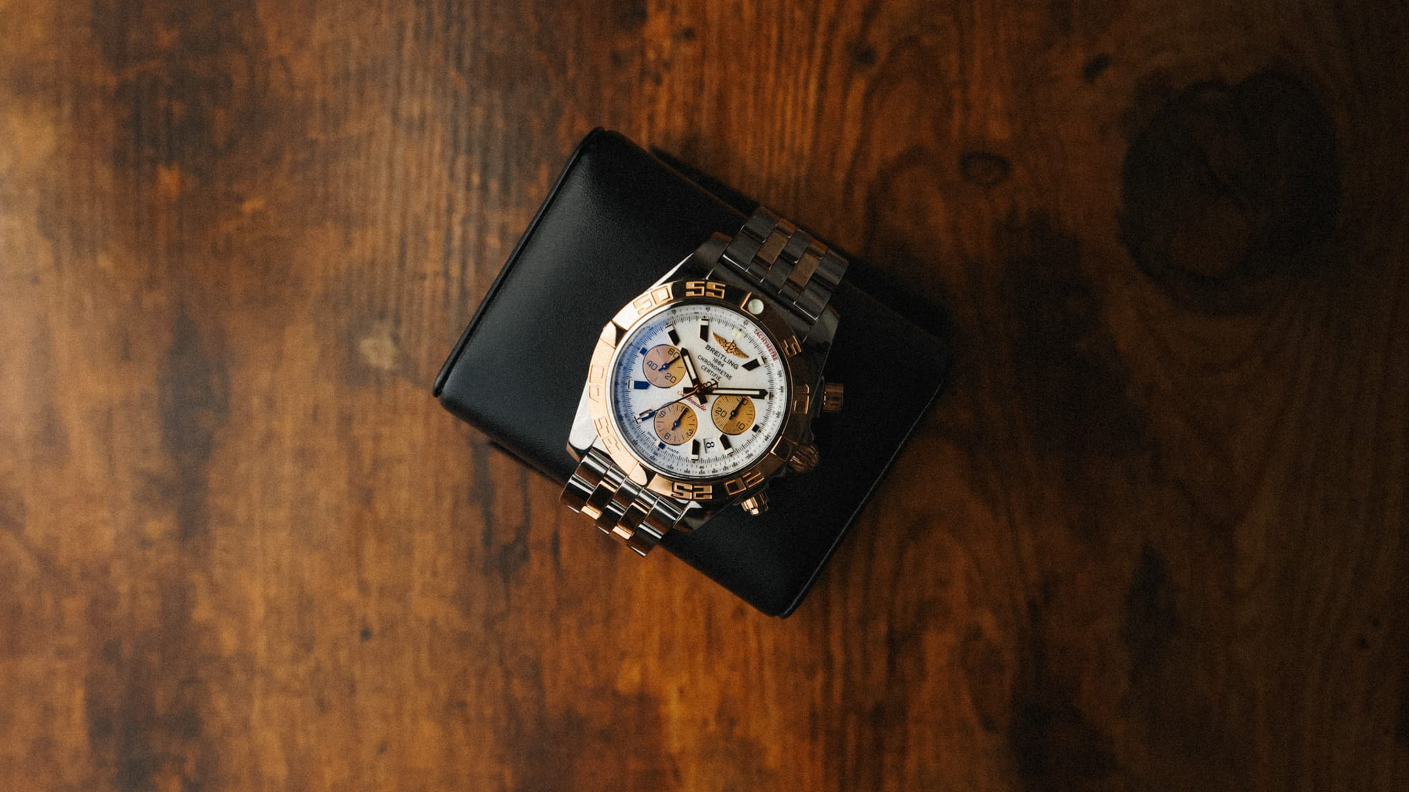 Breitling Chronomat 44mm CB011012A696 with white dial photographed on leather display cushion