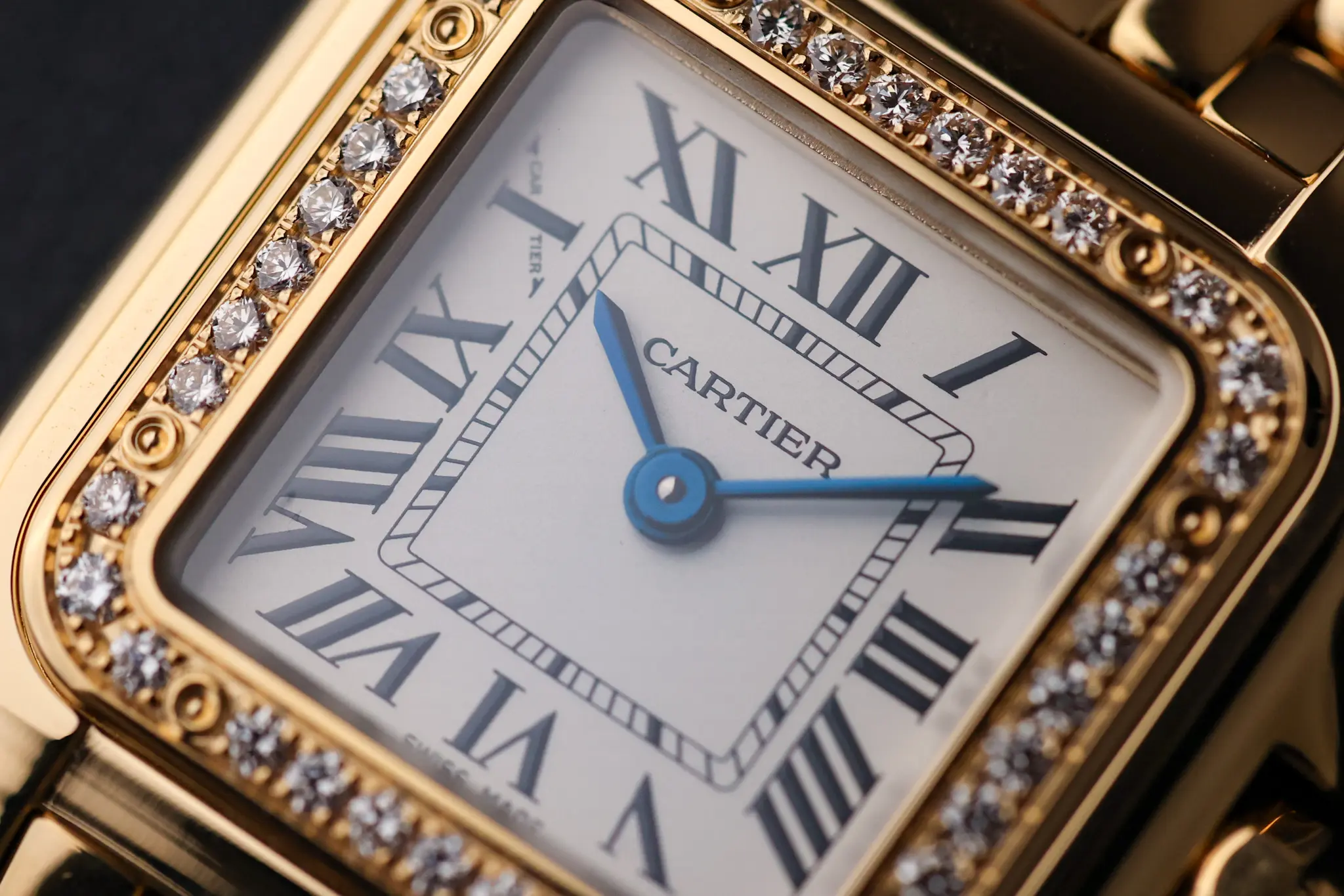 Close-up of Cartier Panthère dial and diamond-set bezel with Roman numerals and blue hands