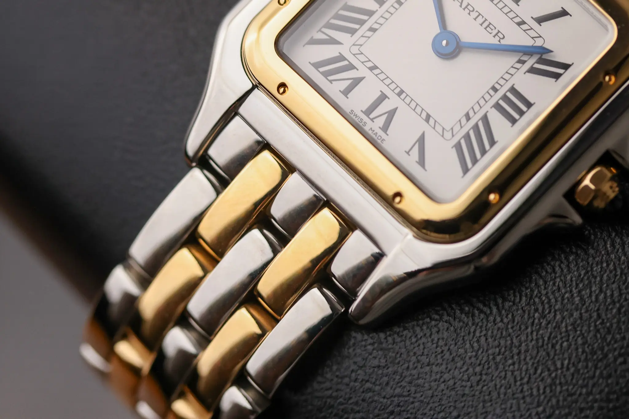 Detailed view of two-tone Cartier Panthère bracelet and case showing polished links and square profile
