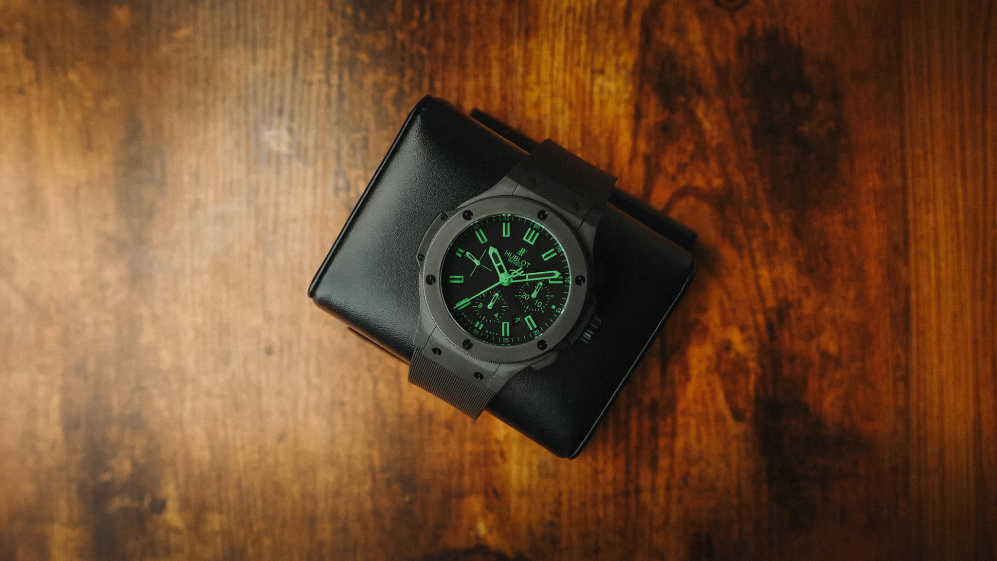 Hublot Big Bang All Black “Green” limited edition watch photographed on a wooden surface