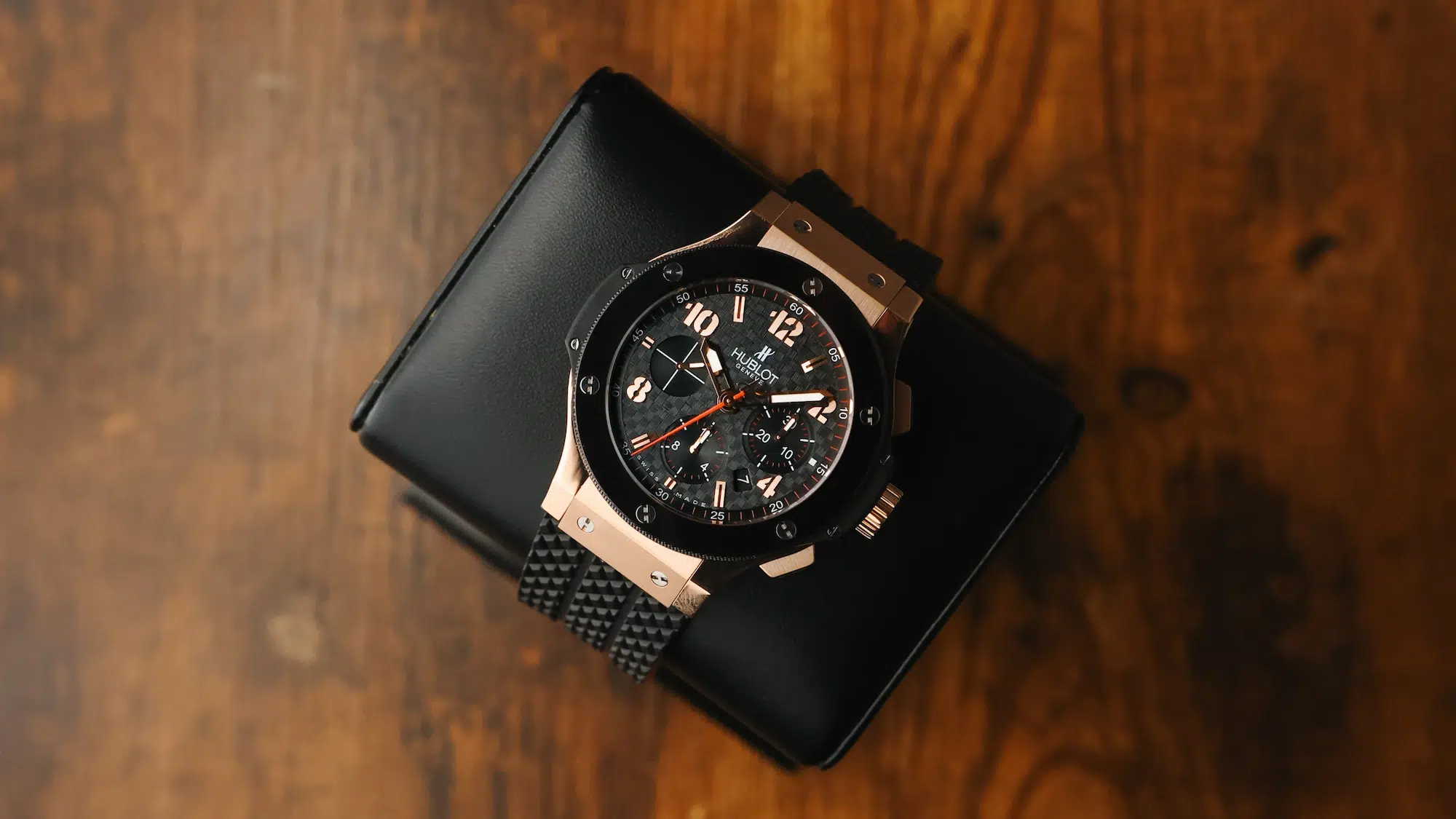 Hublot Big Bang Chronograph in 18K rose gold resting on a leather surface, shown from a distance to highlight the overall case and strap design