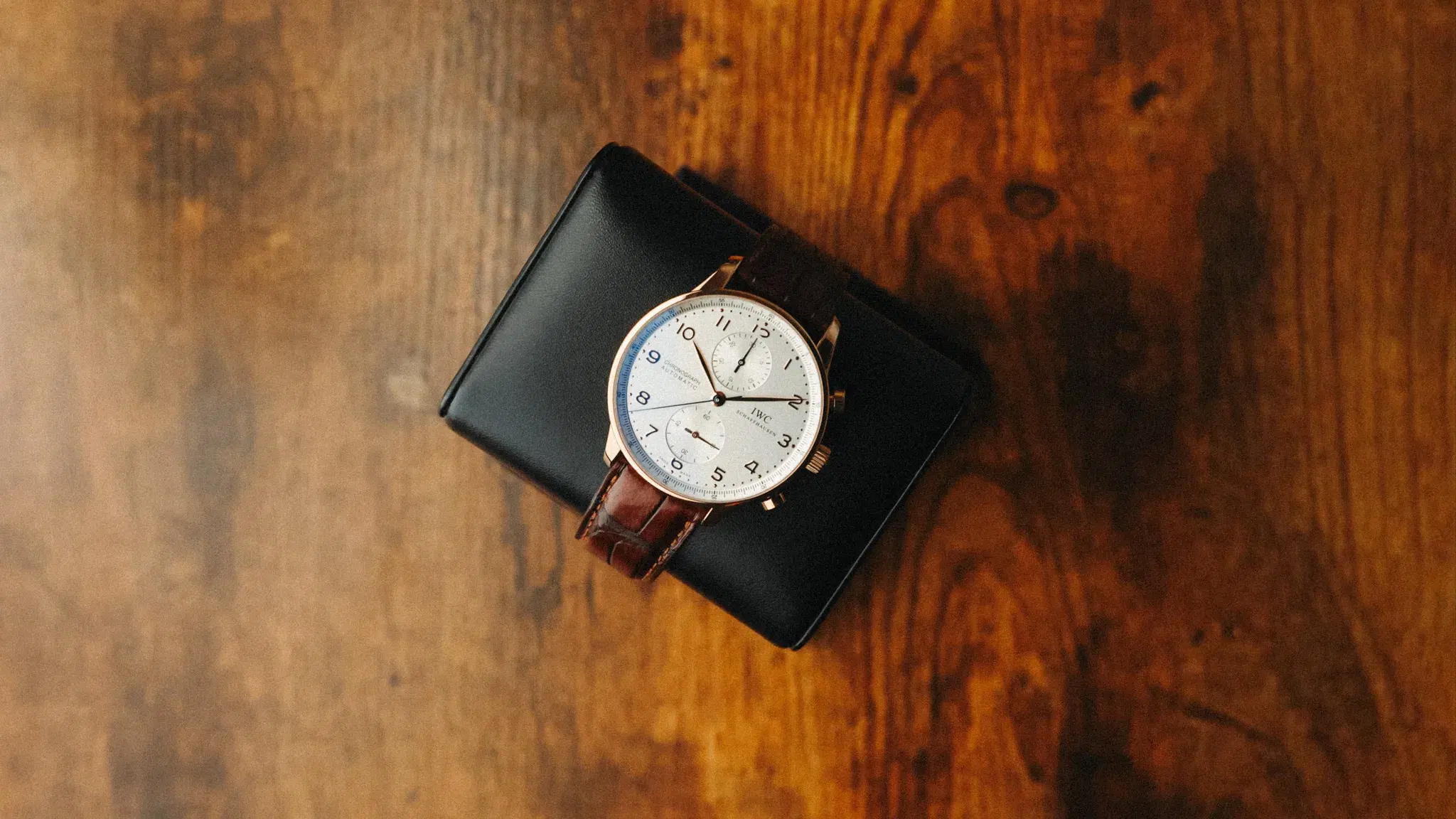 IWC Portugieser Chronograph IW371480 in 18K rose gold resting on leather strap