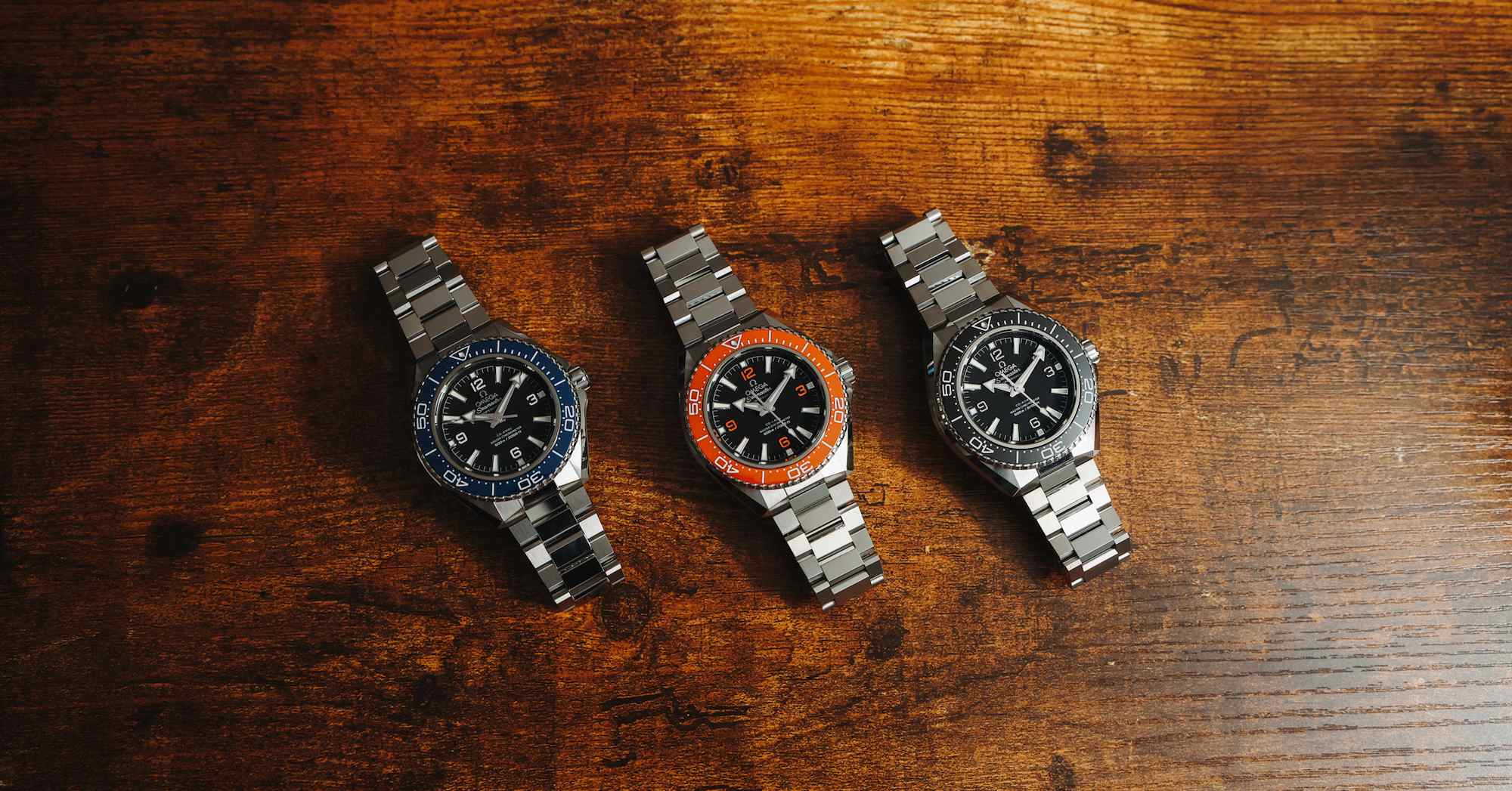 Omega Planet Ocean 600M collection showing the orange, black, and blue fourth-generation models